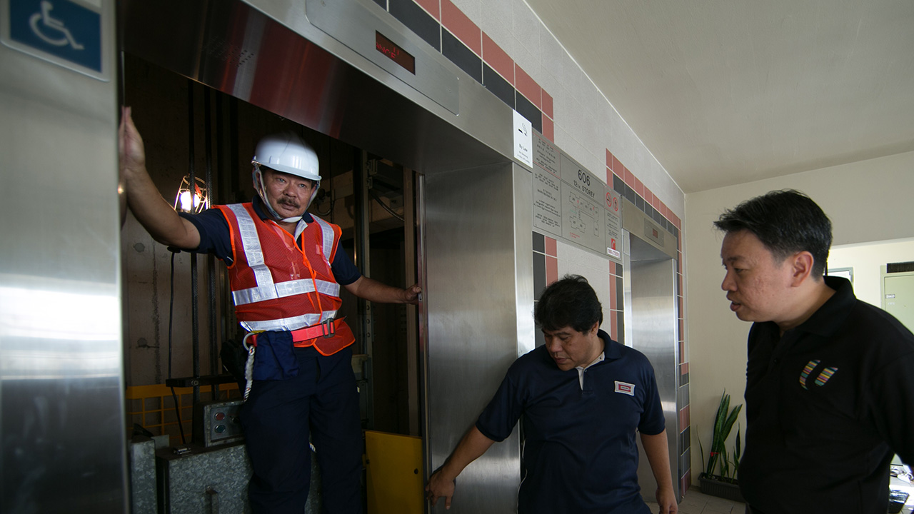 Having a quick chat with the lift technicians in between their servicing work (Photo Source: NTUC)