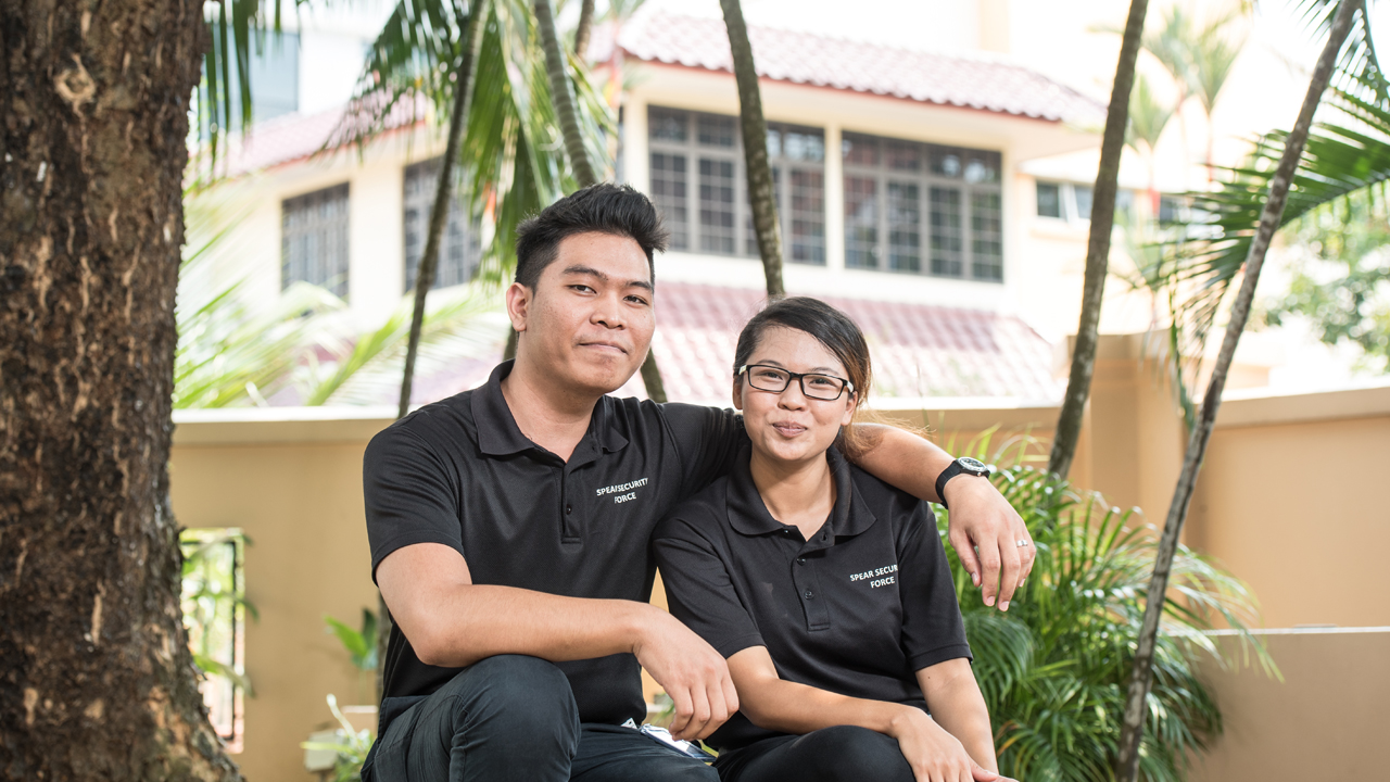 The security line is no walk in the park (pun not intended), but the couple duo have found a way to make it work for them as they continue to learn on the job and achieve career progression with the Progressive Wage Model (Photo Source: NTUC ThisWeek)