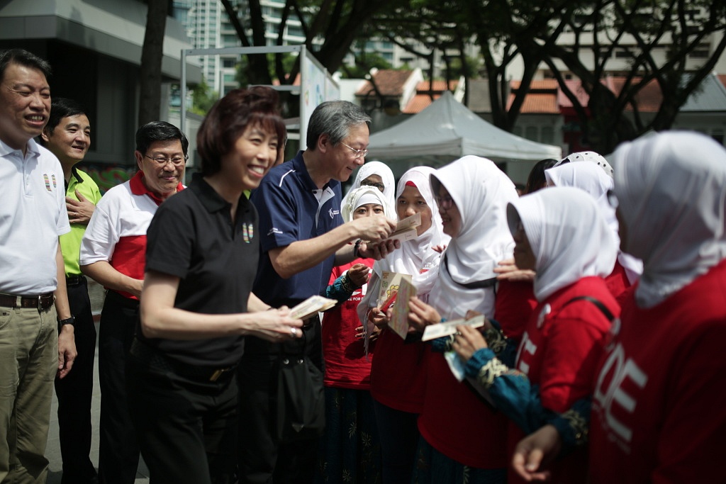 NTUC President Mary Liew and Guest-of-Honour, Mr Sam Tan, Minister of State for Manpower, handing out thank you cards crafted by primary school students to the domestic employees as a token of their appreciation