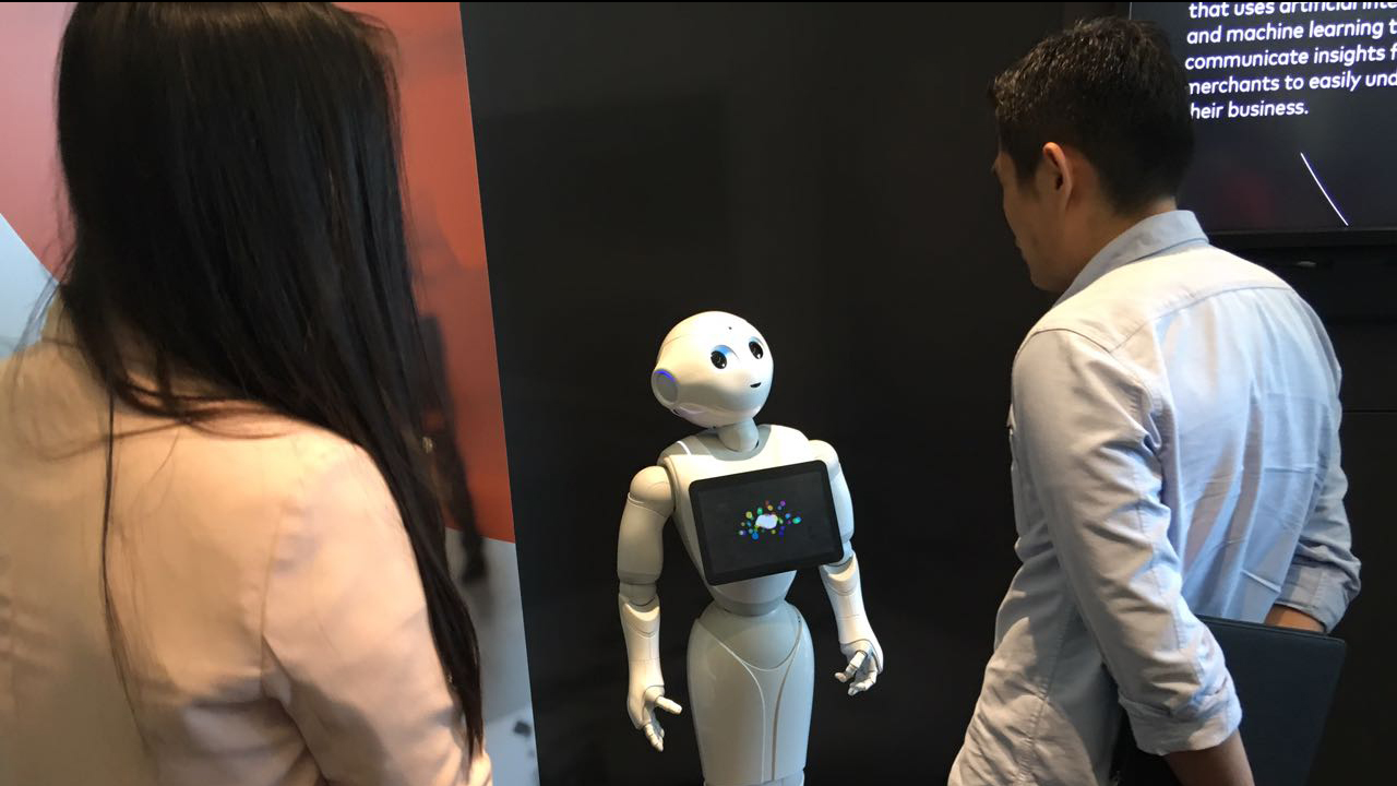 Participants interacting with a robot at the Innovation Exchange to Mastercard Labs.
