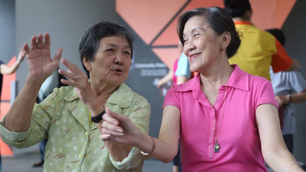 Mdm Hen (right) spends her time interacting with older, less mobile seniors from NTUC Health's senior care centre. 