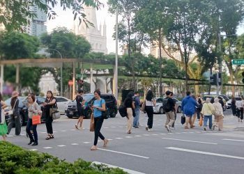 A group of people crossing the street at North Bridge Road in Singapore