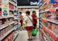 Shoppers browsing at an NTUC FairPrice outlet, where digital vouchers, housebrand items, and weekly promotions help stretch every dollar.