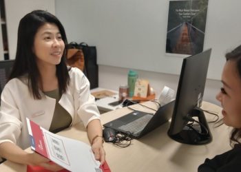 Asian lady serving a client at a career centre.