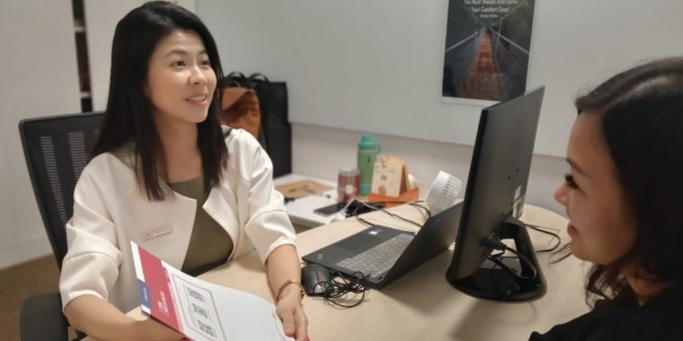 Asian lady serving a client at a career centre.