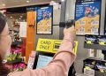 A woman scanning a poster in a supermarket