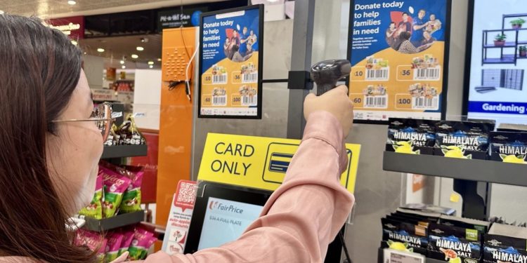 A woman scanning a poster in a supermarket